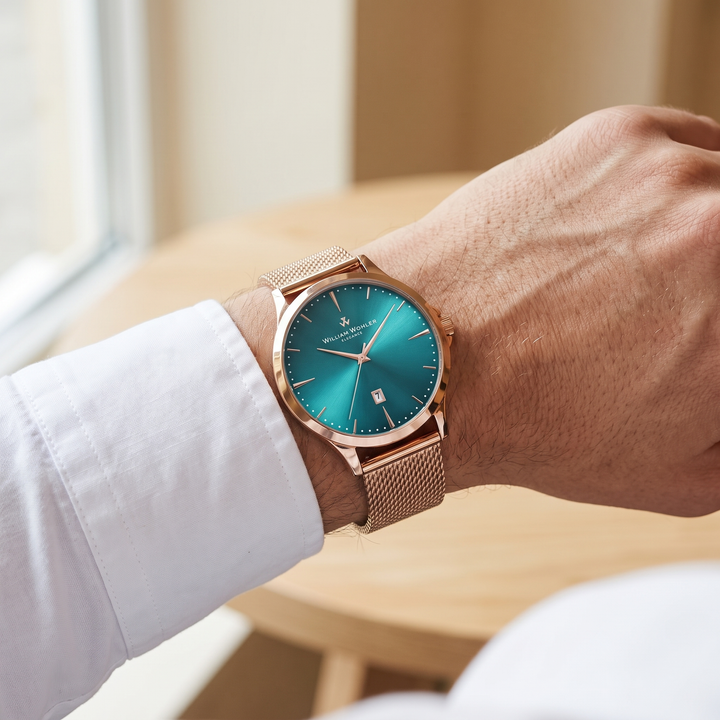 Montre homme Émeraude Dorée William Wohler portée au poignet — maille milanaise or rose et cadran bleu océan