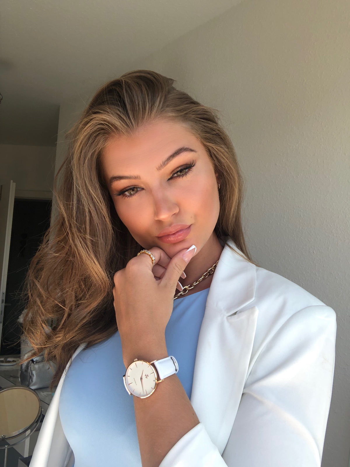 Montre femme Muguet William Wohler en situation, bracelet cuir blanc et boîtier or rose