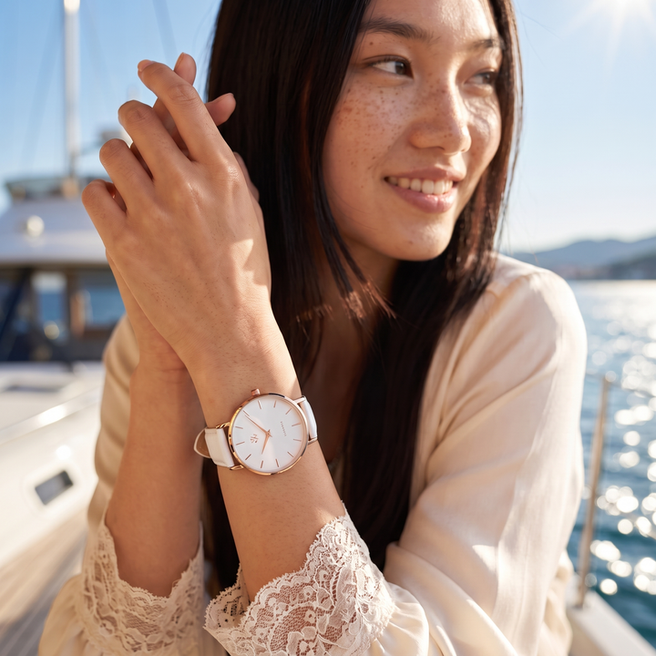 Montre femme Muguet William Wohler au poignet, gros plan sur le cadran et le bracelet cuir blanc